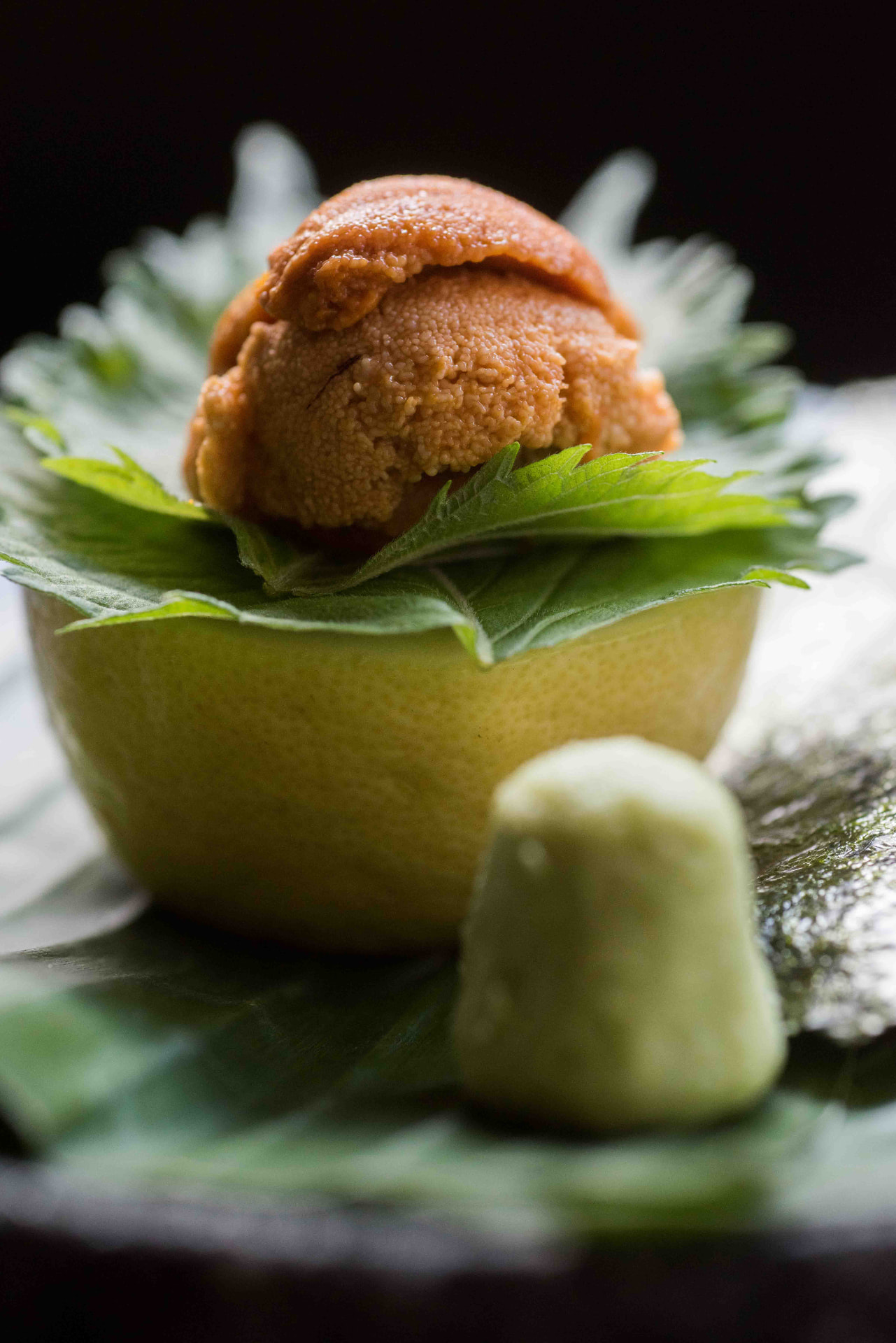 Hokkaido uni served in a hollowed yuzu with shiso leaves and fresh wasabi